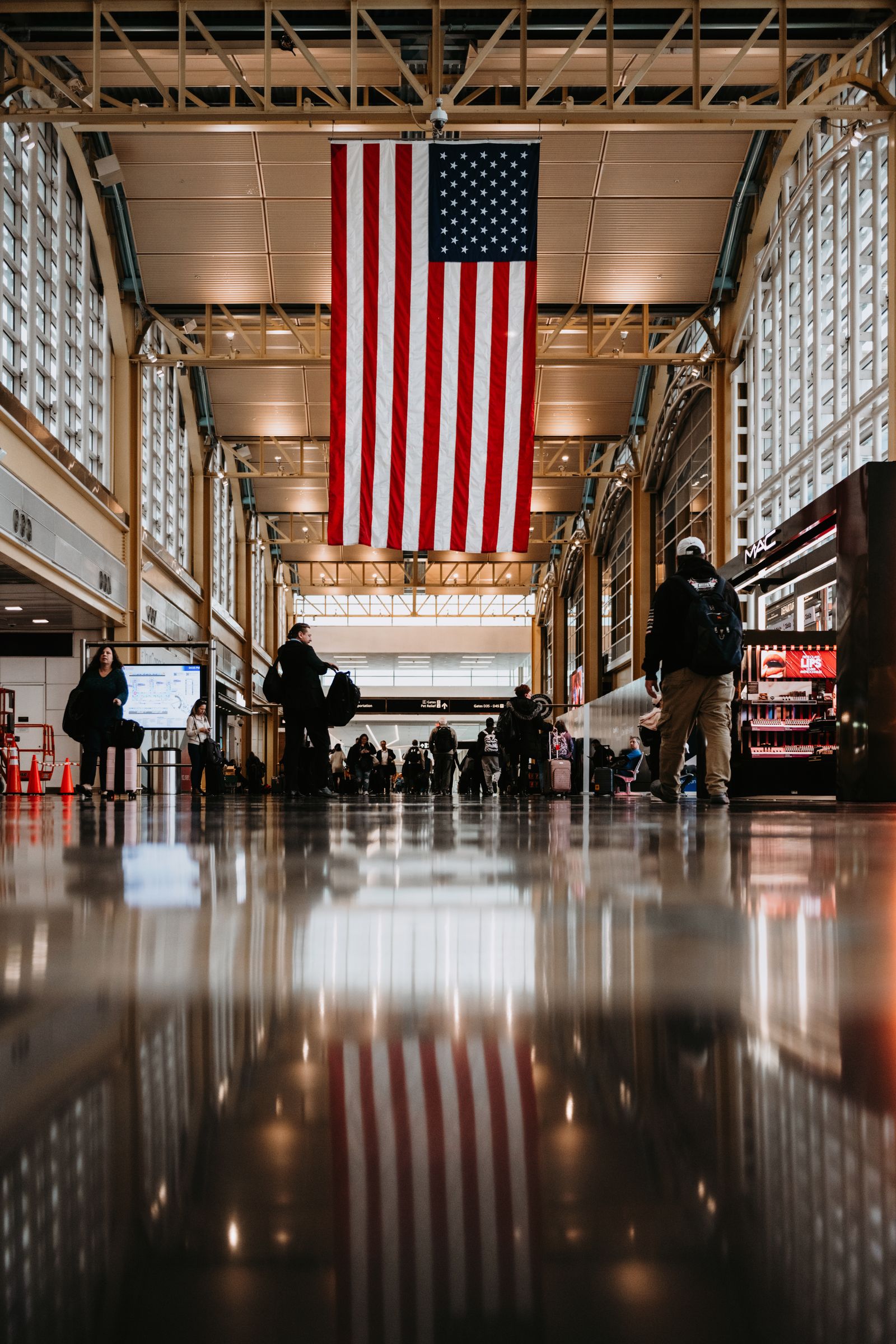 Ronald Reagan Washington National Airport terminal with travelers and an American flag